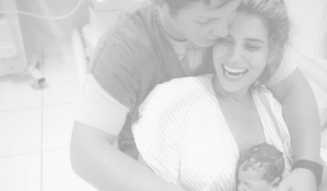 Mae sorrindo com bebe recem nascido casal envolvido ambiente acolhedor. 2